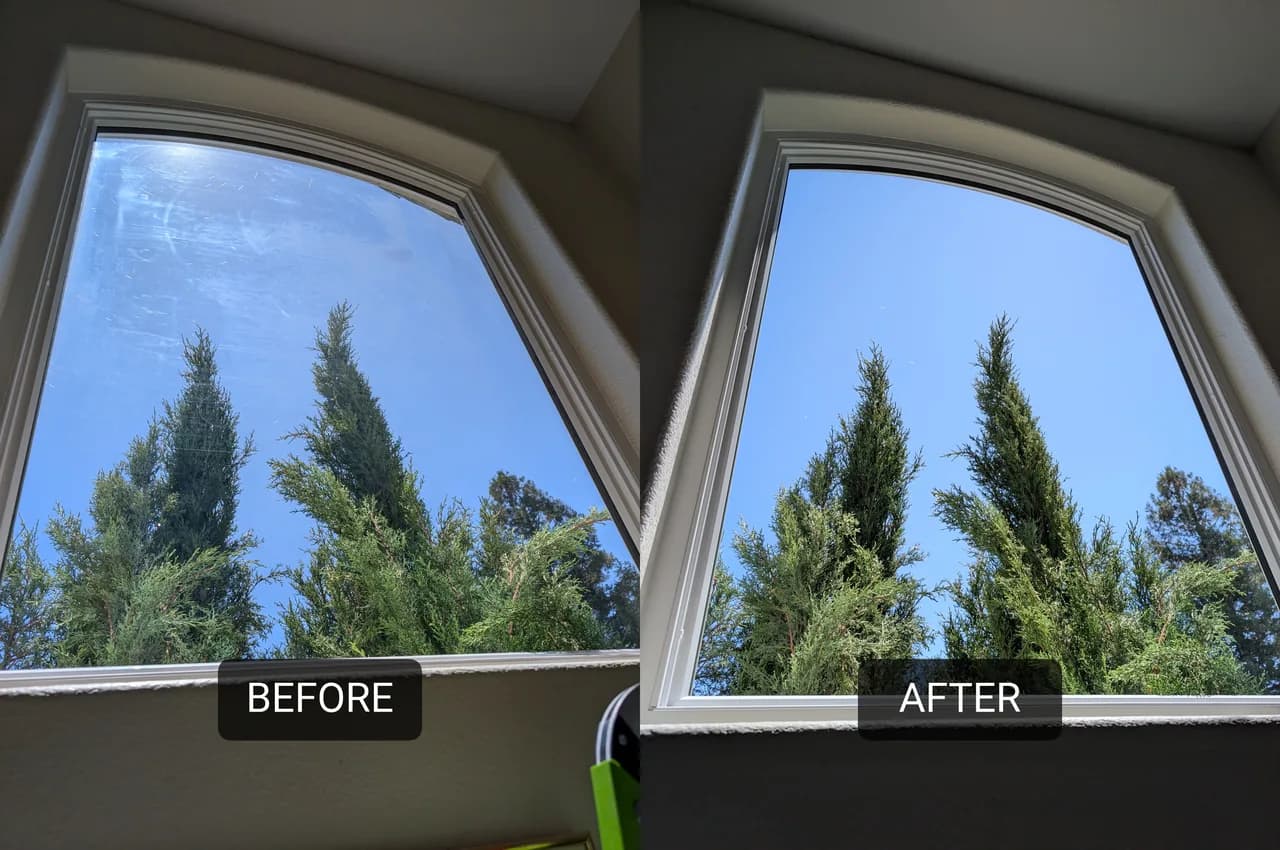 The same arched upper window before and after cleaning. The left half is hazy with a film left by something that had stuck to the glass; the right half is clear enough to read the trees and sky through it.