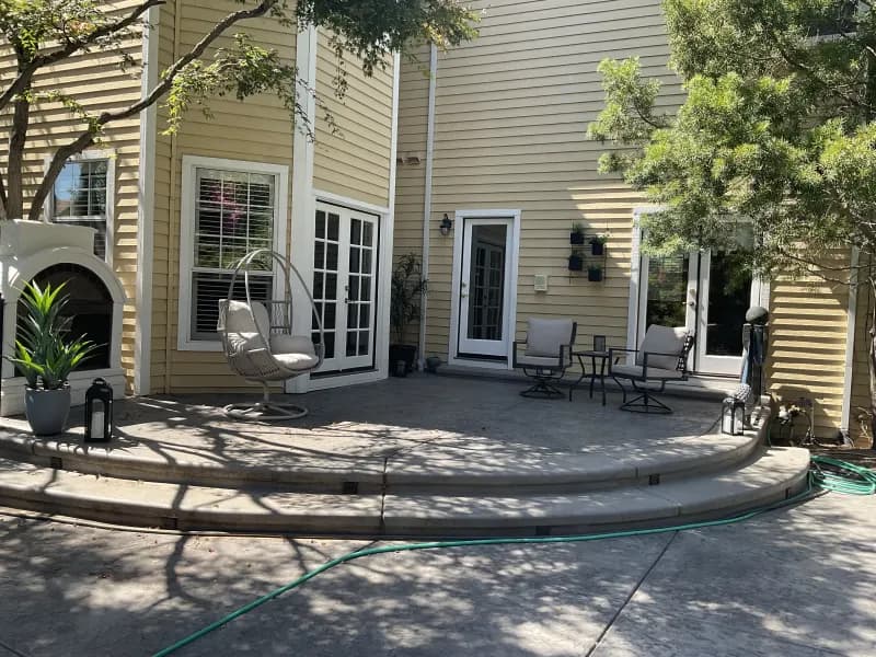 The reviewer's rear patio: french doors, a hanging chair and potted plants, with the glass cleaned.